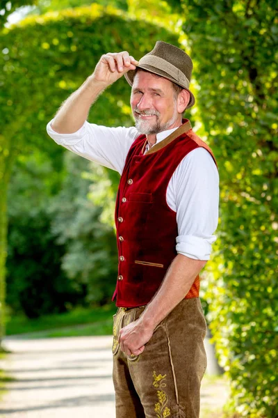 Handsome bavarian man in his 50s standing outdoors in park — Stock Photo, Image
