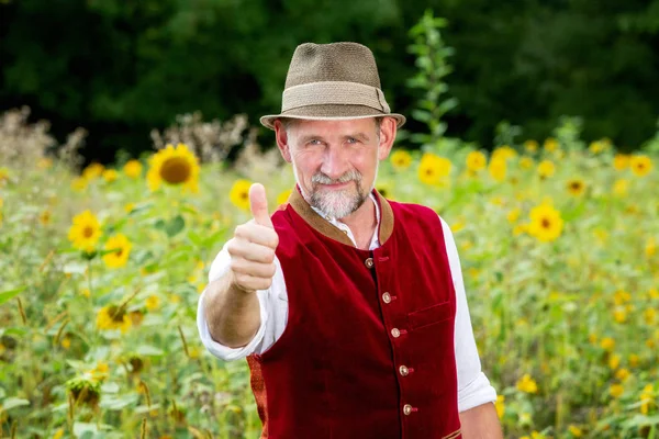 Schöner bayerischer Mann Mitte 50, der mit Daumen im Garten steht — Stockfoto