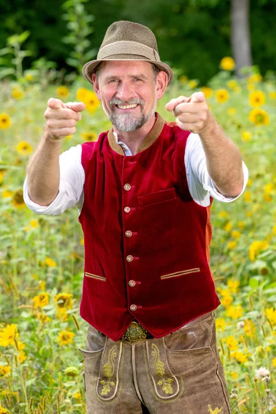 Handsome bavarian man in his 50s standing in garden with thumbs — Stock Photo, Image
