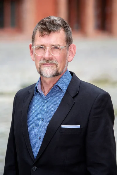 Handsome businessman in his 50s with eyeglasses standing outside — Stock Photo, Image