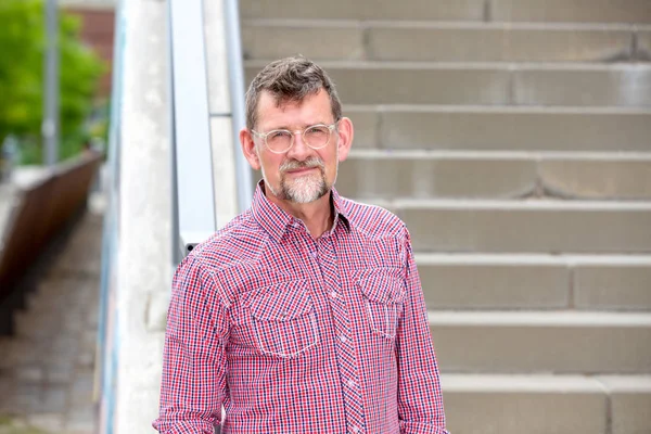 50'li yıllarda, ekose gömlekli yakışıklı adam merdivenlerde ayakta