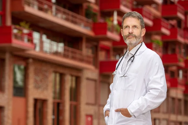 Bello medico barbuto in camice bianco in piedi al di fuori — Foto Stock