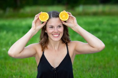 genç kadın kafasına portakal dilimleri tutarak açık havada