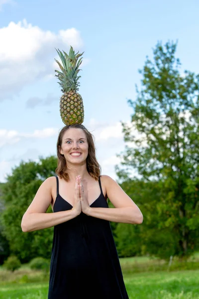 Jovem morena mulher equilibrando um abacaxi na cabeça — Fotografia de Stock