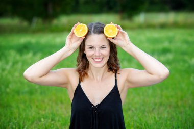 genç kadın kafasına portakal dilimleri tutarak açık havada
