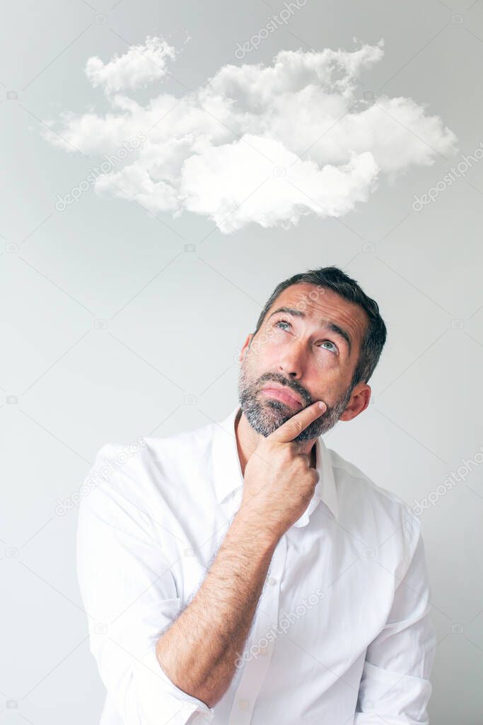 portrait of handsome man looking thoughtful up to a cloud overhead