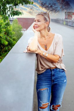 Sarışın kadının portresi köprüde duruyor ve sakin görünüyor.