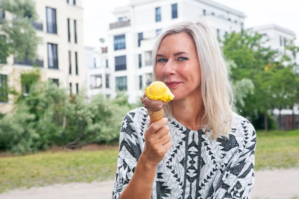 公園でアイスクリームを食べる金髪の女性の肖像画 — ストック写真