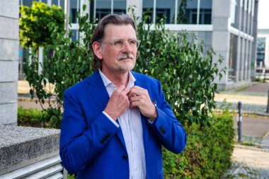 Yakışıklı iş adamının portresi dışarıda tasmasını düzeltiyor.