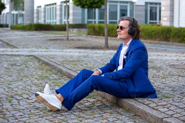 Bonito Empresário Seus Anos Azul Terno Sentado Fora Com Fones — Fotografia de Stock