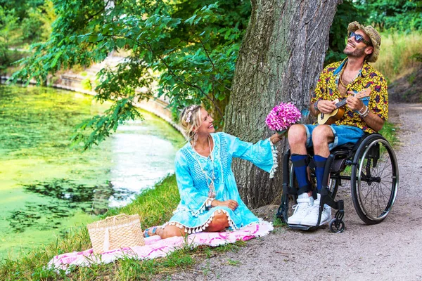 Homem Cadeira Rodas Tocando Guitarra Para Uma Mulher Loira Livre — Fotografia de Stock