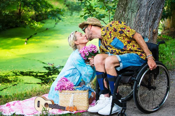 Uomo Sedia Rotelle Baciare Donna Bionda Seduta Vicino Fiume — Foto Stock