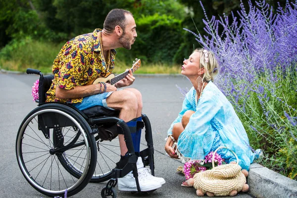 Man Rolstoel Buiten Spelen Van Gitaar Voor Blonde Vrouw Zitten — Stockfoto