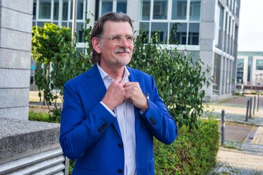 Yakışıklı iş adamının portresi dışarıda tasmasını düzeltiyor.