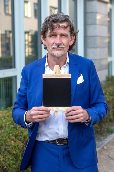 Homem Negócios Bonito Seus Anos Terno Azul Mostrando Pequeno Quadro — Fotografia de Stock