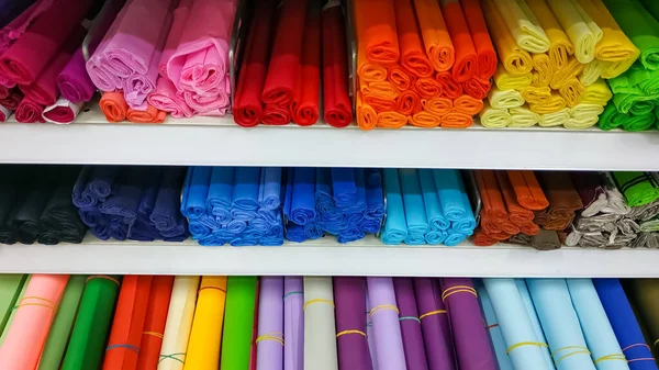 Рулоны цветной бумаги ручной работы, что человек и пенопласт в магазине на полках — стоковое фото
