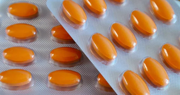Medicines orange oval pills in blister pack closeup