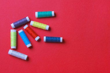 kırmızı renkli kağıt arkaplan üzerinde iplik makarası grubu, kopyalama alanı ile.