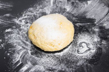 Un üzerinde tatlı bir kalp, hamurun yanında.