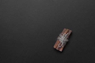 Siyah renkli kağıtta tarçın çubukları fotokopi alanı, üst görünüm.