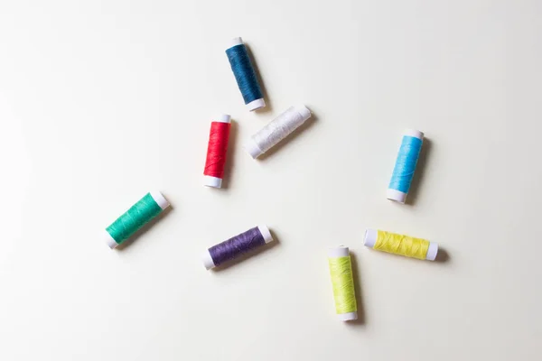 palette of spool of threads on yellow paper background.