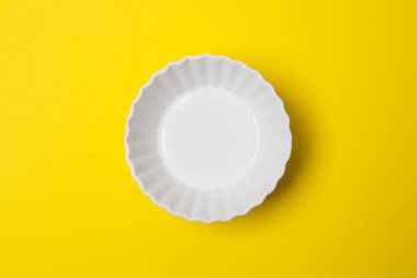 Sarı renkli kağıtta boş beyaz tabak.