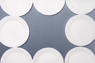 Merkezinde fotokopi alanı olan beyaz çevre dostu kağıt tabaklar. gri arka plan. Üst görünüm.