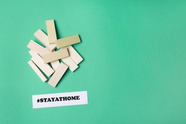 jenga ahşap bloklar telif alanı ve hashtag yeşil renkli kağıt arka planda evde kalır.