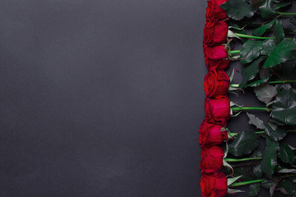 красные розы на правой стороне бальцевого цвета бумажного фона, с копировальным пространством.