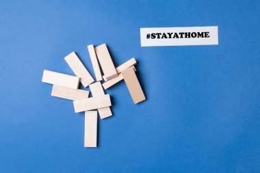 jenga ahşap bloklar telif alanı ve hashtag renkli kağıt arka plan üzerinde evde kalın.