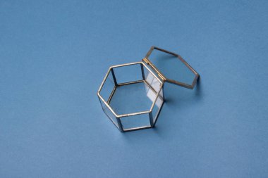 Cam mücevher kutusu mavi renkli kağıt arka planda, yakın plan..