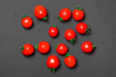 Kırmızı domates ya da kirazlı siyah renkli kağıt arkaplan. en üstteki görünüm.