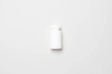 Beyaz plastik tıbbi konteynır sarı renkli kağıtta bulunan haplar için..