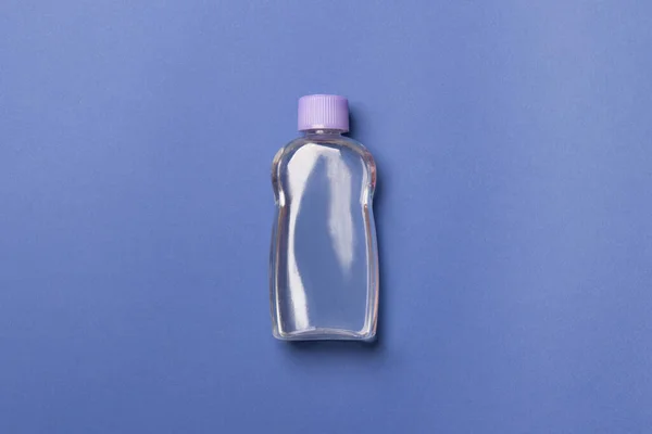 液体が青い背景に横たわっている紫色の化粧品ボトル — ストック写真