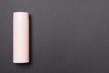 Siyah arkaplanda fotokopi alanı olan pembe termos bardağı.