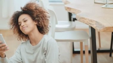 Güzel genç afro Amerikalı kadın cep telefonu evde kullanma.