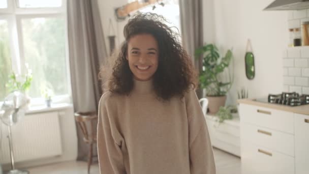台所でカメラに笑顔の美しい若い女性の肖像画 — ストック動画
