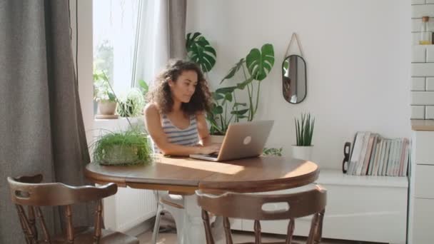 自宅のラップトップ コンピューターに入力する魅力的な若い女性 — ストック動画