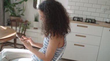 Sevimli genç esmer kadın telefonunuzun ve modern şık daire.