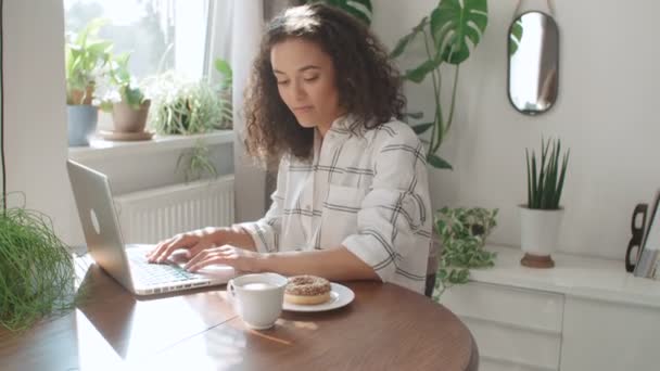 自宅のラップトップ コンピューターに入力する魅力的な若い女性 — ストック動画