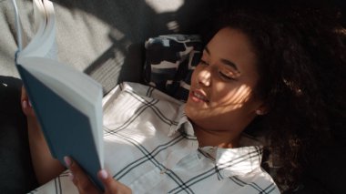 Güzel Afro Amerikalı kadın okuma kitabı evde.