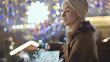 Bir şehirde Noel pazarında genç gülümseyen kadın portresi.