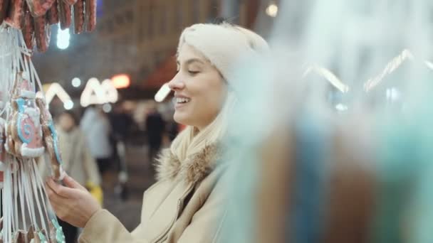 年轻的金发女孩在一个城市的圣诞市场的乐趣 — 图库视频影像
