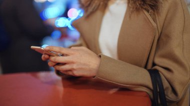 Kadın elinde telefon kullanarak kapatın. Cep telefonuyla bir şehirde gece genç kadın.