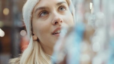 Genç sarışın kız eğleniyor bir şehirde Noel pazarında.