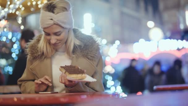 Kvinna Med Smartphone Julmarknad Lycklig Attraktiv Kvinna Äta Våffla Med — Stockvideo