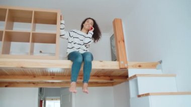 Telefonunuzun ve modern şık daire sevimli genç kadın.