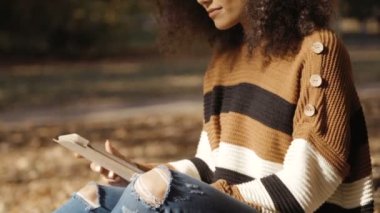 Tablet bilgisayar, açık kullanarak siyah kıvırcık saçlı güzel genç kız.