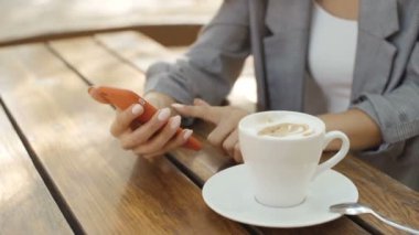 Bir şehir parkında telefonunu kullanarak siyah kıvırcık saçlı güzel genç kız. 