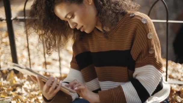 タブレット コンピューター 屋外を使用して暗い巻き毛の美しい少女 — ストック動画